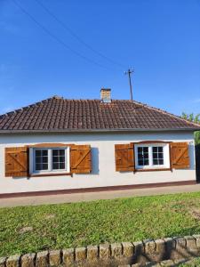 ein Haus mit Holzfenstern und einem Dach in der Unterkunft Kuća za odmor Iva in Turija