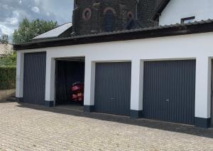 un garaje con dos puertas de garaje con un coche dentro en Gasthaus Schürmann en Üdersdorf