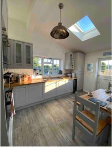 a kitchen with white cabinets and a table and a window at Near Woodbridge The Annexe Eyke Fantastic views with Dog secure Garden and Paddock in Eyke
