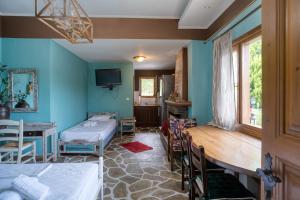 a room with two beds and a table and chairs at Stefania's Houses in Zagora