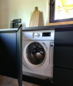 uma máquina de lavar roupa debaixo de um balcão numa cozinha em Sosnowy Plan em Józefów