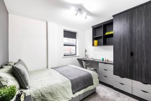 a bedroom with a bed and a black cabinet at Hot Deal - Luxury Apartment close to Leeds City Centre in Leeds