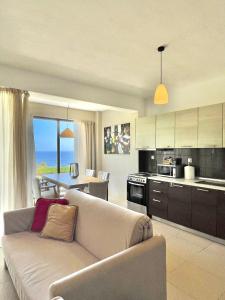 a living room with a couch and a kitchen at Koumaros Villas in Agia Paraskevi