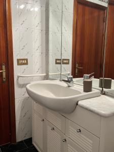 y baño con lavabo blanco y espejo. en Casa Elena, en Arezzo