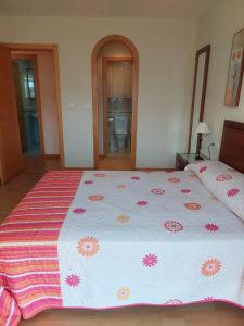 ein Schlafzimmer mit einem großen Bett mit Blumen darauf in der Unterkunft Apartamento cerca de la playa in Kap Finisterre
