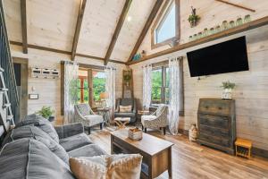 ein Wohnzimmer mit einem Sofa und einem Flachbild-TV in der Unterkunft Modern Willis Cabin Retreat 24-Acre Working Farm! in Willis