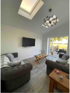 a living room with two couches and a flat screen tv at Near Woodbridge The Annexe Eyke Fantastic views with Dog secure Garden and Paddock in Eyke