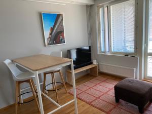 una pequeña sala de estar con mesa y TV. en Rauhallinen asunto, sauna ja iso parveke - raitiovaunureitin varrella en Tampere