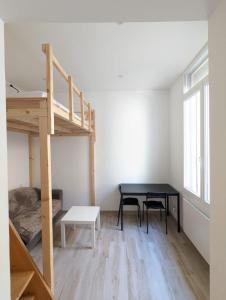 ein Schlafzimmer mit einem Etagenbett, einem Tisch und einem Schreibtisch in der Unterkunft Comfortable studio of 18 m for 2 people in Montpellier