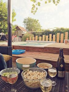 a table with bowls of food and a bottle of wine at Petit havre de tranquillité in Loudun