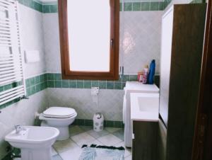 a bathroom with a white toilet and a sink at Appartamento da Monica in Tortolì