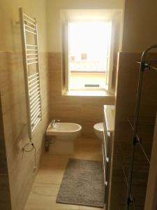 bagno con lavandino, servizi igienici e finestra di NIDO DI ELEONORA a Poggio