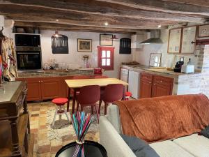 - une cuisine avec une table et des chaises dans la chambre dans l'établissement Le grand Moulin, à Pernay