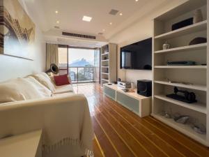 uma sala de estar com uma cama e uma televisão e um quarto em Camarote VIP Vista Mar e Por do Sol em Ipanema A1-009 no Rio de Janeiro