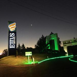 um sinal em frente a um edifício com luzes verdes em Ettus em Caxias do Sul