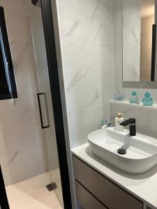 een witte badkamer met een wastafel en een douche bij Bubble House in La Rochelle