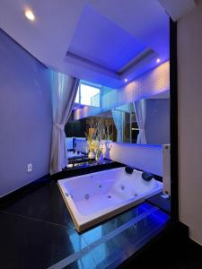 a large bathroom with a large tub with blue lighting at Ettus in Caxias do Sul