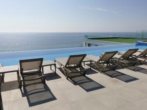 a group of chairs and a table on a roof at Alee Infinity Pool & Spa in Mamaia Sat/Năvodari