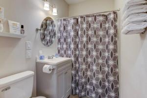 a bathroom with a shower curtain and a sink at Spring Bungalow - A cozy getaway in downtown Hot Springs! in Hot Springs
