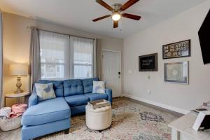 a blue couch in a living room with a ceiling fan at Spring Bungalow - A cozy getaway in downtown Hot Springs! in Hot Springs