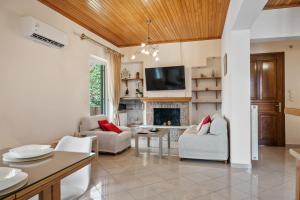 a living room with white furniture and a fireplace at Lefkes Apartment in Lygia