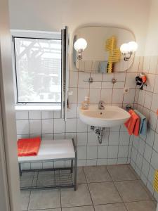 a white bathroom with a sink and a mirror at Bungalow in Stralsund