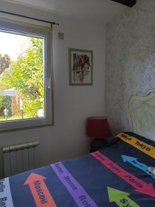 Schlafzimmer mit einem Bett mit Schild in der Unterkunft Maison proche rivière in Ruoms