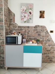 a kitchen with a microwave on top of a counter at DIMORA MELISSA in Colà di Lazise