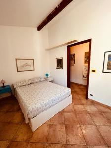 - une chambre avec un lit blanc et une porte dans l'établissement Eremomarino apartment, à Livourne
