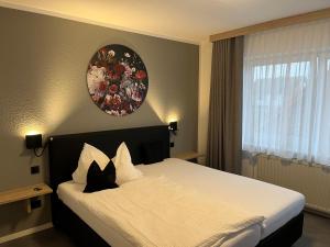 1 dormitorio con 1 cama grande con zona de estar en la pared en Hotel Papenbreer, en Verl
