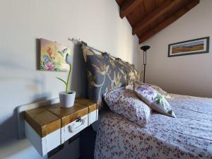 a bedroom with a bed with a wooden night stand at La Casa del Colibrì in Lecco