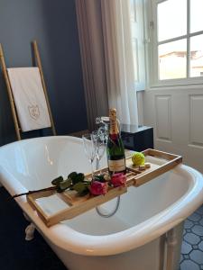 a white bath tub with a bottle of wine and glasses at Conquistador Palace in Guimarães
