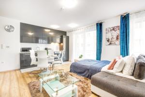 a living room with a bed and a kitchen at Modern apartment with free garage and balcony in the downtown in Budapest