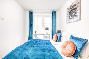 a bedroom with blue curtains and a bed with blue pillows at Modern apartment with free garage and balcony in the downtown in Budapest
