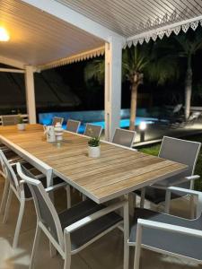 een houten tafel en stoelen op een patio bij La Villa Manee in La Saline les Bains