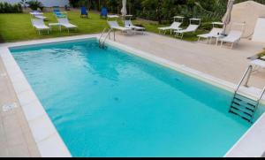 una gran piscina azul con sillas alrededor en Casa Veda elegant Rooms, en Fiumefreddo di Sicilia