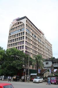 een groot gebouw met auto's geparkeerd voor het bij Hotel Rajmahal in Guwahati