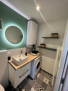 uma casa de banho com um lavatório e uma máquina de lavar roupa em STUDIO OSAKA - HYPER CENTRE LORIENT em Lorient