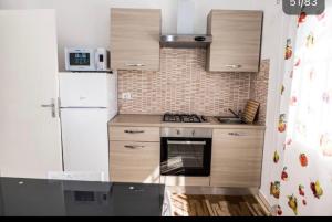 uma pequena cozinha com um frigorífico e um fogão em Casa Veda elegant Rooms em Fiumefreddo di Sicilia
