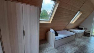 a small room with a bed and a window at DOMKI NAD ŁOWISKIEM in Giżycko