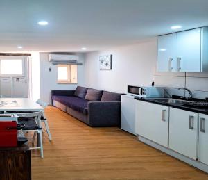 ein Wohnzimmer mit einem Sofa und einer Küche in der Unterkunft Apartment in Castelo in Lissabon