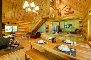Cabaña de madera con cocina y sala de estar. en Secluded Log Cabin in NW Michigan Fire Pit and Deck, en Evart