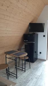 uma mesa e cadeiras num quarto com um frigorífico em DOMKI NAD ŁOWISKIEM em Giżycko