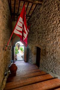 モンタルチーノにあるIL PALAZZO DEL CARDINALEの石廊下を飛ぶ赤白旗