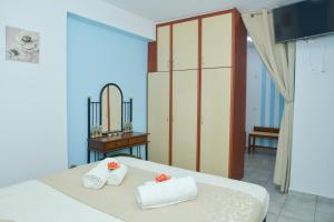 ein Schlafzimmer mit einem Bett mit Handtüchern und einem Spiegel in der Unterkunft nikola's house in Adamas