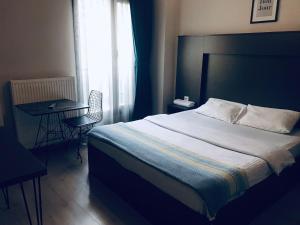 um quarto com uma cama, uma mesa e uma janela em OTTO LOFT Premium Apartments em Ancara