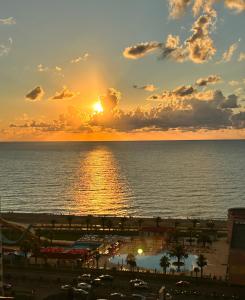 a sunset over the ocean with the sun setting at Black Sea Apartament in Batumi