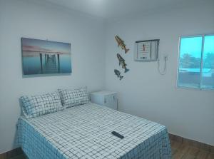 パウリスタにあるPousada e Hotel Malibuのベッドルーム1室(ベッド1台、リモコン付)