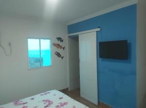 a bedroom with a bed and a window and bats on the wall at Pousada e Hotel Malibu in Paulista
