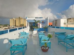 パウリスタにあるPousada e Hotel Malibuの青い椅子とテーブル、アビザー付きの屋上パティオ